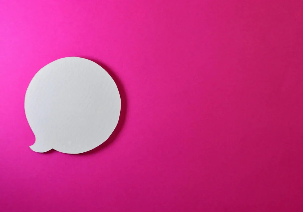 Minimalist pink background with a white speech bubble for creative design projects.